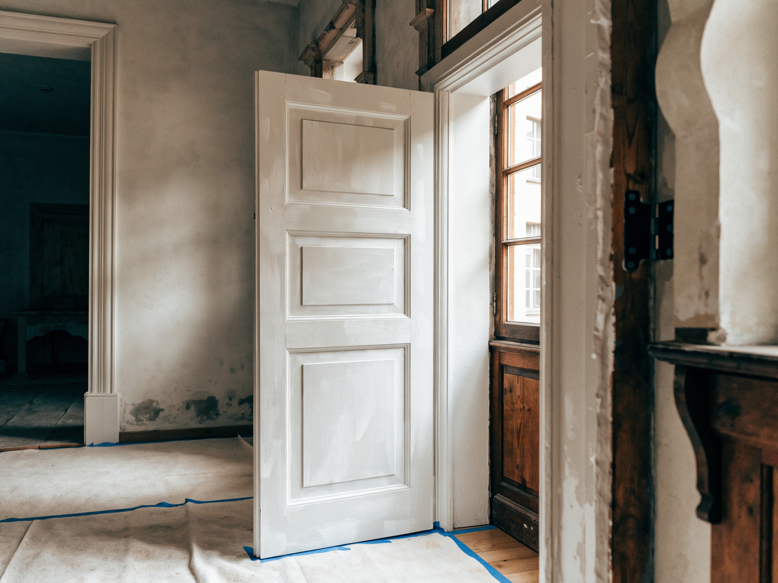 Frisch abgeschliffener und lackierter Türrahmen mit Holztür im Altbau